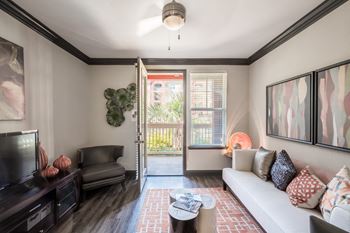 a living room with a couch and a door to a balcony